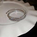 Macro detail of silver multi-layer zircon wrap bracelet on a white decorative dish - Style 30 / Silver