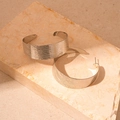 Detail of silver brushed metal hoop earrings showcasing a refined matte textured surface - Silver