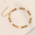Primer plano de pulsera bohemia con perlas de agua dulce, piedras y cierre dorado - Jaspe Paisaje