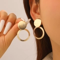 Detailed view of golden heart-shaped geometric earrings with brushed texture on ears - Brushed Double Circle Earrings (2177)