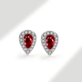Close-up of teardrop silver stud earrings with red pear-cut stone and pavé zircon border - 925 Silver / Garnet (January)