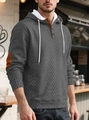 Detail eines grauen Hoodies mit Rautensteppung und kontrastierenden Ellenbogenschonern - Dunkelgrau