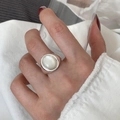Silver adjustable ring with white oval shell stone inlay on model's hand - Oval Shell Minimalist Ring (J3966)