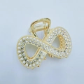 Detail der Infinity-Haarklammer mit Perlen und Strasssteinen auf Gold-Metall-Oberfläche - Goldener Twist
