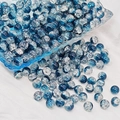 Macro view of blue crackle glass beads on white fabric for DIY jewelry making - 8mm / Ink Blue White