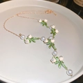 Detailed macro view of gold lily of the valley necklace with pearls and green leaves - Lily of the Valley Pearl (Gold)