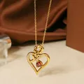 Close-up of gold titanium steel heart necklace with rose detail and zircon inlays - Gold Red Stone Necklace N0451G