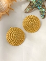 Detail of gold geometric round earrings with woven texture on a white beach setup - Round Scale Texture