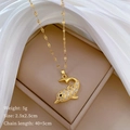 Detail of gold dolphin pendant necklace with cz stones on beige jewelry box and silk - Dolphin Style (C511) / Gold