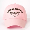 Close-up detail of Cheese Muffin embroidery on a pink cotton twill baseball cap - One Size / Light Pink