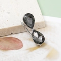 Eleganter silberner Haarclip mit schwarzen Tropfenkristallen auf Natursteinstruktur - Silberne Basis Grau