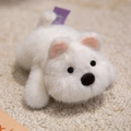 Cute plush white puppy magnet with long soft fur and purple tag in a lying pose - Westie