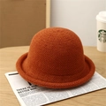Close-up of orange knitted bucket hat showing rich woven texture and rolled brim detail - Brick Red