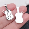Silver musical guitar pendant charm on a fingertip showing front and back details - Guitar (15x25mm-1.8g)