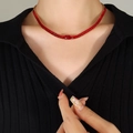 Elegante collana dorata con pietre di zircone rosso indossata da una modella - Collana Rossa