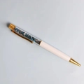 Dettaglio di una penna a sfera bianca e oro riempita con pietre di cristallo colorate - Refill Nero 14cm / Apatite