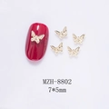 Macro shot of 7x5mm mini golden metal butterfly nail charms on a deep red nail - Gold Textured Butterfly (8802) / 7*5mm