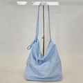 Detail of blue and white gingham canvas bag with unique knot decoration on shoulder strap - Blue Plaid