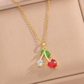 Golden cherry necklace with heart-shaped red stone and green leaf in a jewelry box - Cherry Necklace (440) / Gold