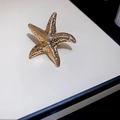 Detailansicht des goldenen Seestern-Anhängers mit strukturierter Metalloberfläche - Seestern Ring / Gold