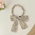 Dettaglio del cerchietto floreale con perle bianche e catene dorate dal design elegante - Verde Grandi Fiori