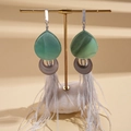 Close-up of ethnic style resin earrings with natural feathers on a minimalist display - Emerald Green Water Drop Feather