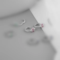 Close-up of silver snake earrings with pink gemstone eyes in minimalist style - Platinum (Pink Eyes)