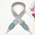 Detail of adjustable woven blue and beige bag strap with gold metal hooks and leather trim - Light Blue & Light Blue