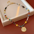 Detail of vintage gold-plated circular smile pendant with colorful beads on a display - Colorful