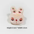 Detail of plush beige bunny charm with red cherry embroidery measuring 5.5cm by 5.5cm - Orange Pink