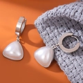 Elegante dreieckige Perlenohrringe mit silbernem Titanstahlreif auf orangefarbenem Grund - Huggie Dreieck Perlenohrringe / Silber