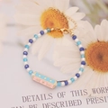 Detalle macro de pulsera hecha a mano con cuentas y colgante de estrella esmaltada - Estilo Estrella