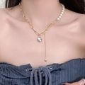 Asymmetric gold chain pearl necklace with rhinestone pendant and tassel detail on model - Gold Patchwork Chain Artificial Pearl Rhinestone Tassel Necklace (X1612B)