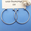 Top view of two minimalist silver open bangles with polished metal beads on blue surface - Open Bead Bangle / Silver