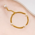 Dettaglio di un bracciale dorato a strati con quattro perle bianche su seta rosa - Bracciale