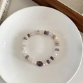 Artistic beaded bracelet with natural amethyst, pearls, and stones on a ceramic plate - Natural Stone & Crystal Bracelet
