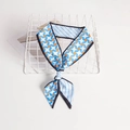 Blue and orange geometric star pattern twilly silk scarf tied in a bow - Blue Geometric