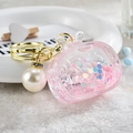 Pink acrylic TV-shaped liquid keychain with glitter, pearls, and golden metal hardware - Noctilucent TV Style / Pink
