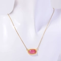 Golden necklace with a horizontal red rectangular gemstone pendant on a white mannequin - October Necklace