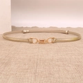 Detail of skinny metallic gold belt with decorative metal interlocking buckle on burlap texture - Gold
