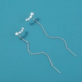 Detail of silver star-shaped long tassel earrings with sparkling zircon on blue background - Star Tassel Ear Threader