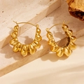 Macro detail of gold plated croissant hoop earrings with elegant pleated texture on stone - U-shape Hill