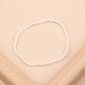 Minimalist handmade white seed bead bracelet on a beige textured background - Style 56-Thin White Seed Beads