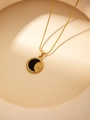 Gros plan d'un collier doré avec pendentif lune émaillé noir et chaîne serpent élégante - Lune Céleste Noire