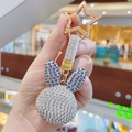 Close-up of rabbit keychain with blue and white rhinestones and star-shaped clip - Purple