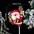 Santa Claus cake topper holding colorful gift boxes for festive Christmas decoration - Acrobatic Santa Claus with Gift Boxes Soft Glue / Approx. 4.7x6cm