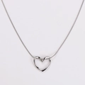 Detailed close-up of a silver hollow heart pendant on a minimalist snake chain necklace - Steel