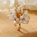 Macro view of floral ring with white imitation pearls and a gold-tone open band - Champagne (WR1066)