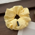 Coletero de tela amarillo brillante con etiqueta Blind for Love sobre fondo de madera - Amarillo