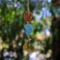 Detail of handmade woven moon and star pendant with red and blue raw crystals - Tiger Eye + Green Aventurine (Gold Accessories)